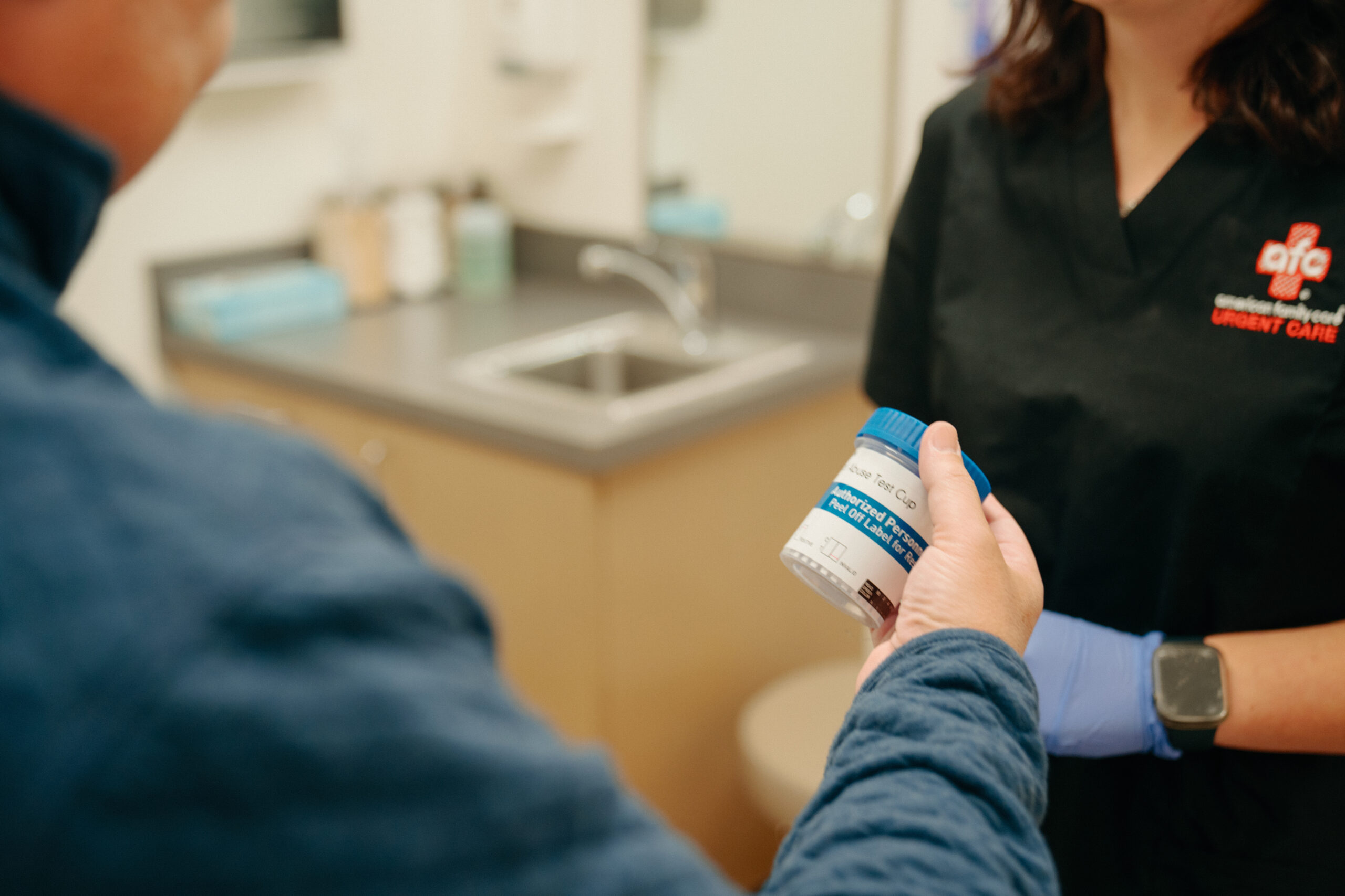 A man holding a cup in the doctor's office.
